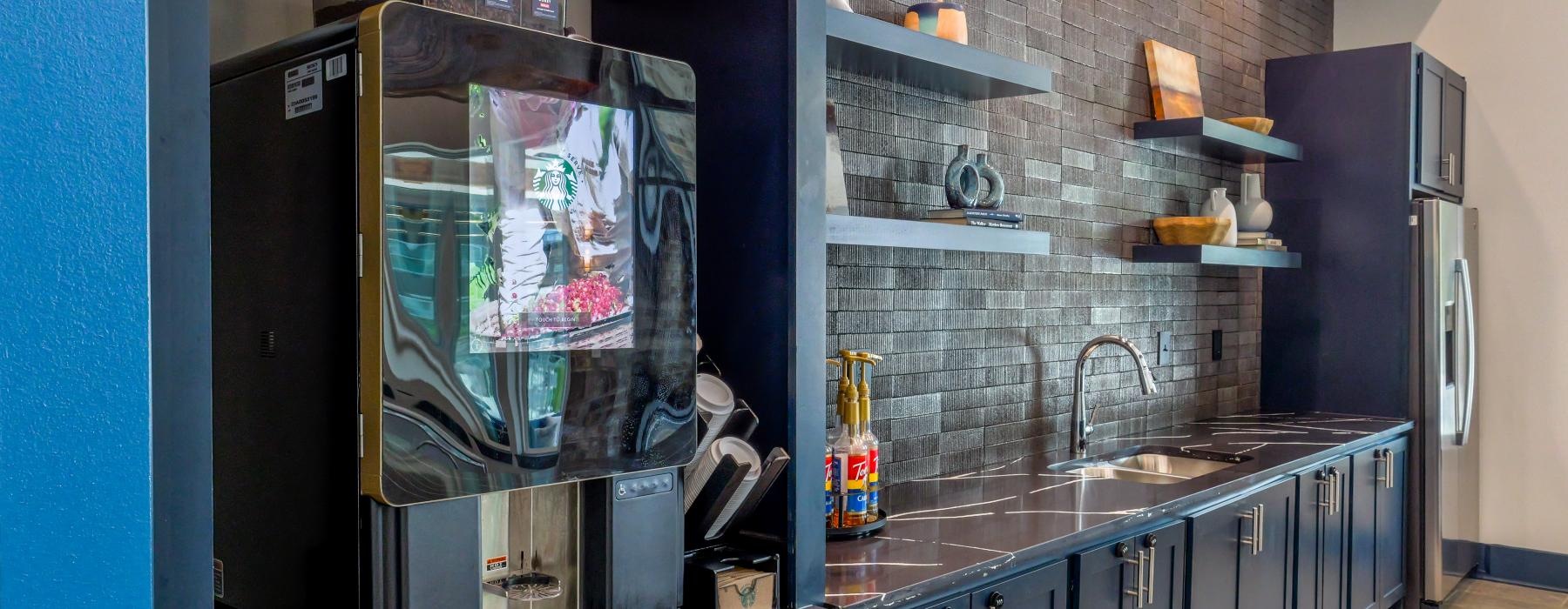 a clubhouse kitchen with a coffee machine and a refrigerator