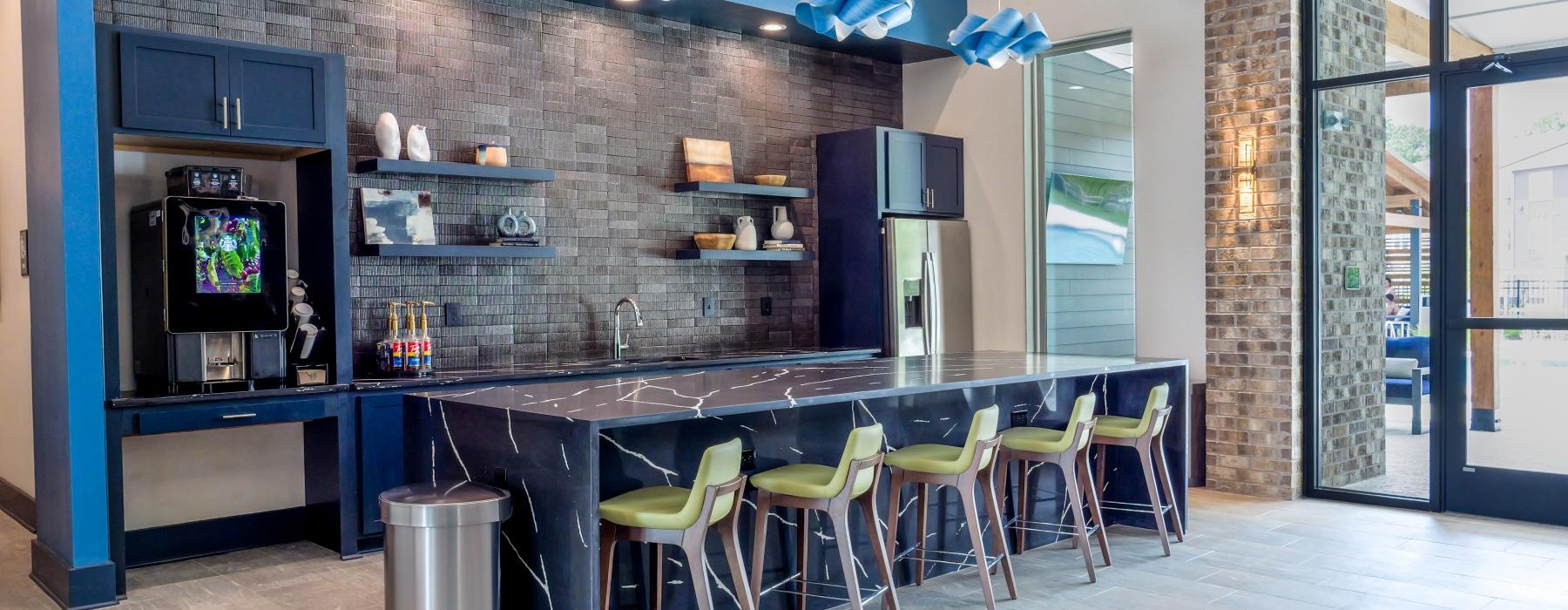a clubhouse kitchen with a bar and chairs