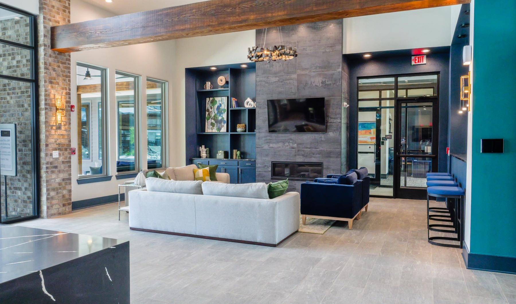 a clubhouse lounge room with a couch, tv and a fireplace