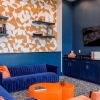a clubhouse room with a tv, a large couch and a table
