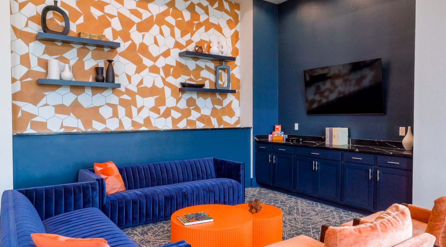 State-of-the-art amenities a clubhouse room with a tv, a large couch and a table