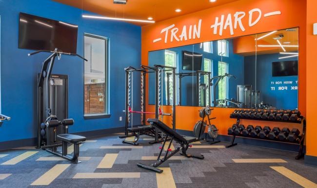 Quick access to state-of-the-art amenities a gym front with a tv and exercise equipment