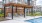 a patio with chairs and a table in front of a pool