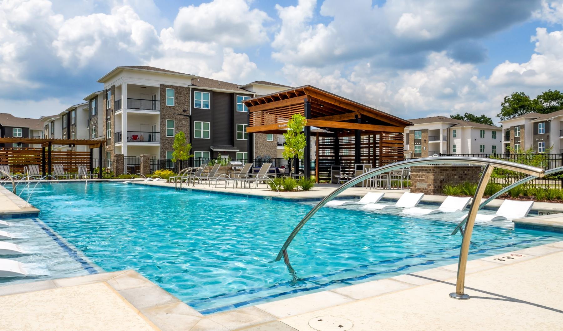 Resort-style swimming pool a swimming pool with a building in the background