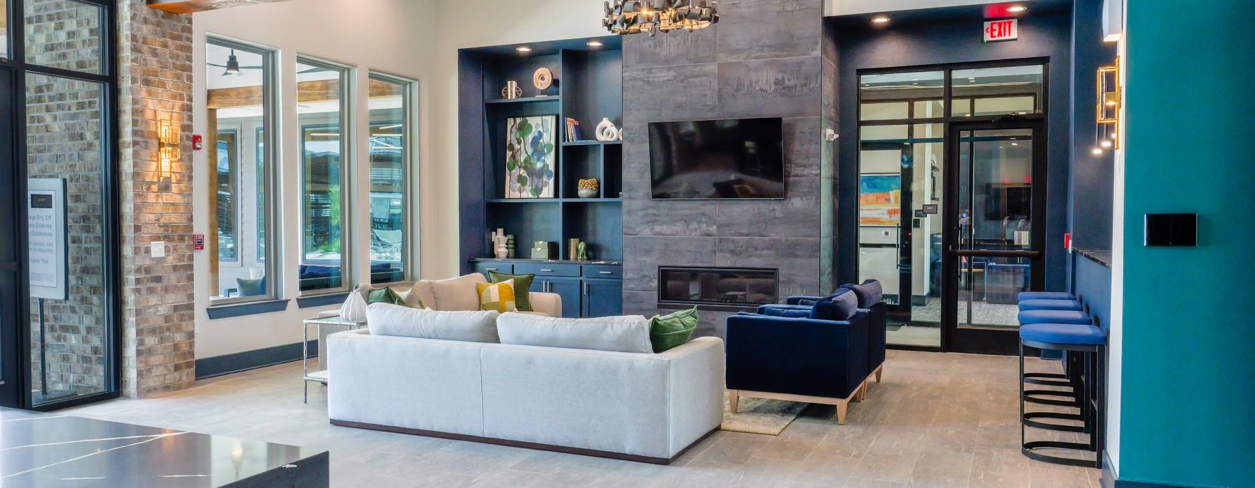a clubhouse lounge room with a couch, tv and a fireplace