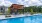 a swimming pool with chairs and a covered patio